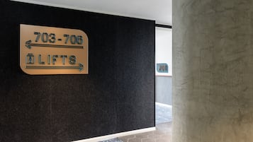 A sign indicating the location of the lifts with directional arrows and a phone number.