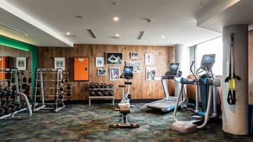 A gym with treadmills, elliptical machines, and weightlifting equipment.