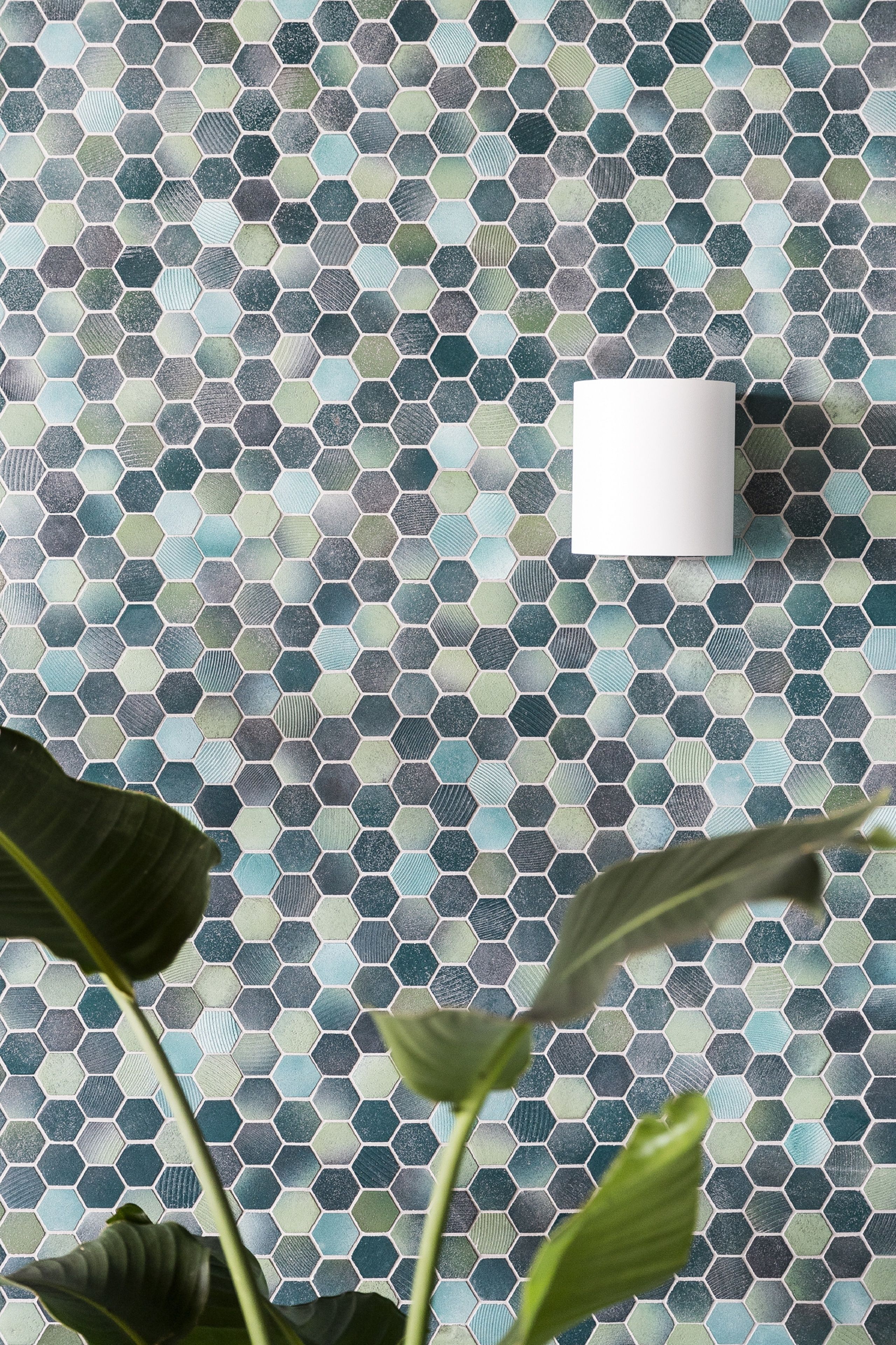 Pared con un diseño de baldosas hexagonales y un objeto blanco sobre ella.