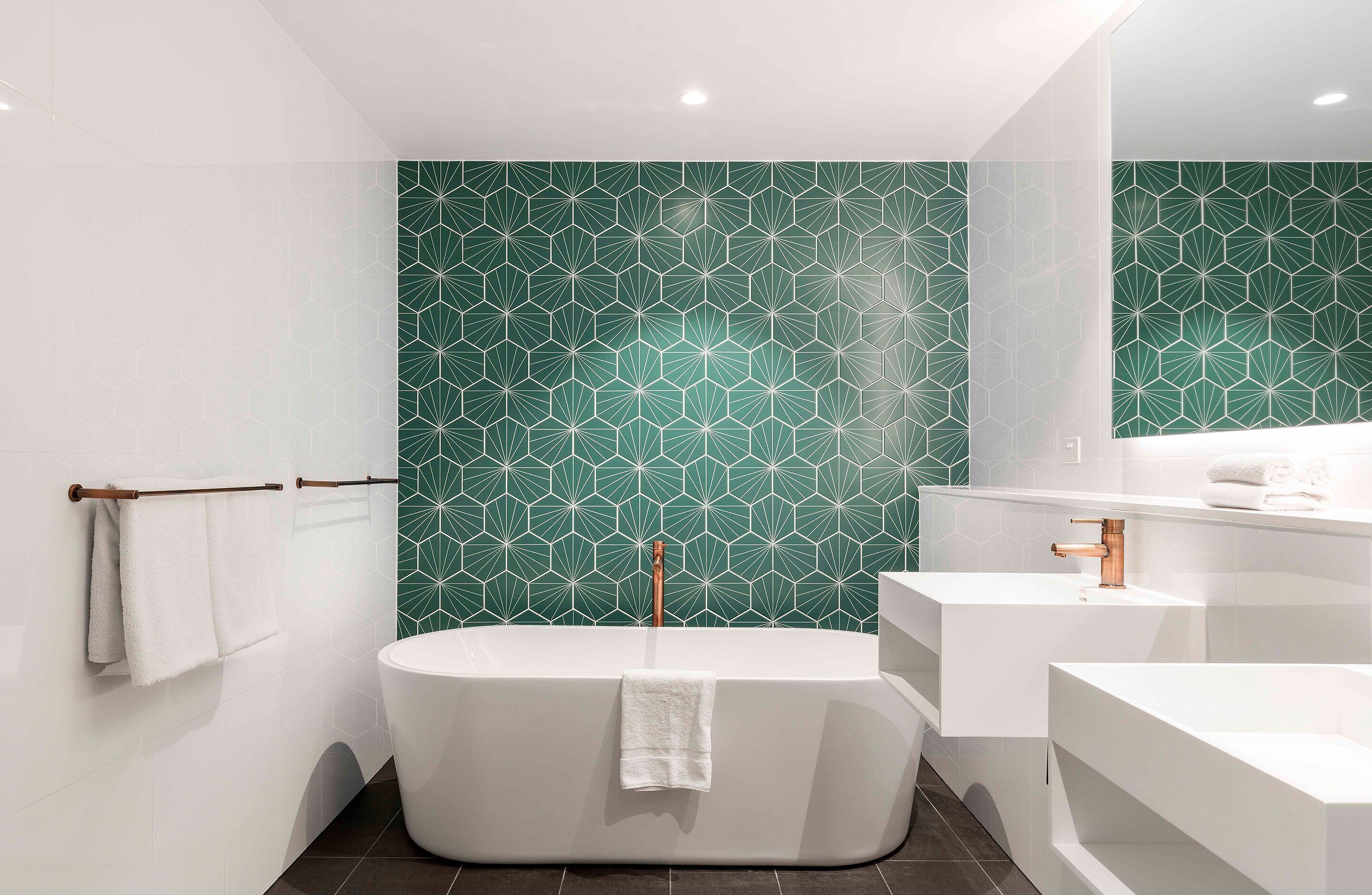 Une salle de bain moderne avec une baignoire sur pieds, un lavabo blanc et un grand miroir.