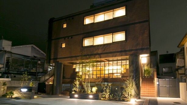 A modern building with multiple windows and a well-lit entrance.