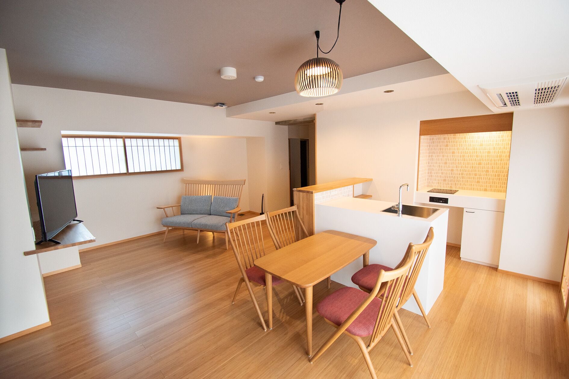 A compact living space with a dining area, a kitchenette, and a seating area with a television.