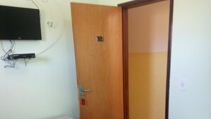 A room with a bed, a desk, and a chair. There is a television mounted on the wall. - Pousada Cariri (Juazeiro do Norte)