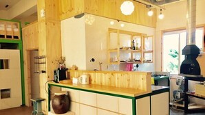 A kitchen with wooden cabinets, a central island, and a built-in grill. - Family Hotel Oliva (Jeju City)