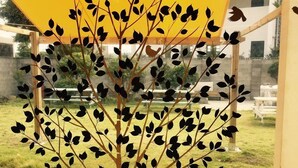 A tree with black leaves and a yellow canopy, with a quote about trees and breathing. - Family Hotel Oliva (Jeju City)