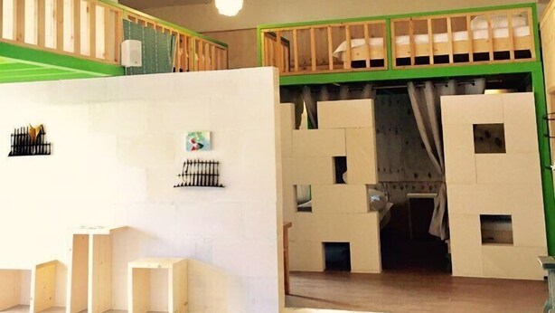 A room with a high ceiling, a staircase, and a bunk bed structure. - Family Hotel Oliva (Jeju City)