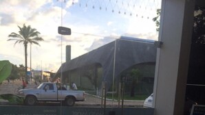 Un hall d’accueil d’hôtel offrant une vue dégagée sur la rue, où l’on peut apercevoir une voiture blanche garée et un immeuble doté d’une grande auvent.