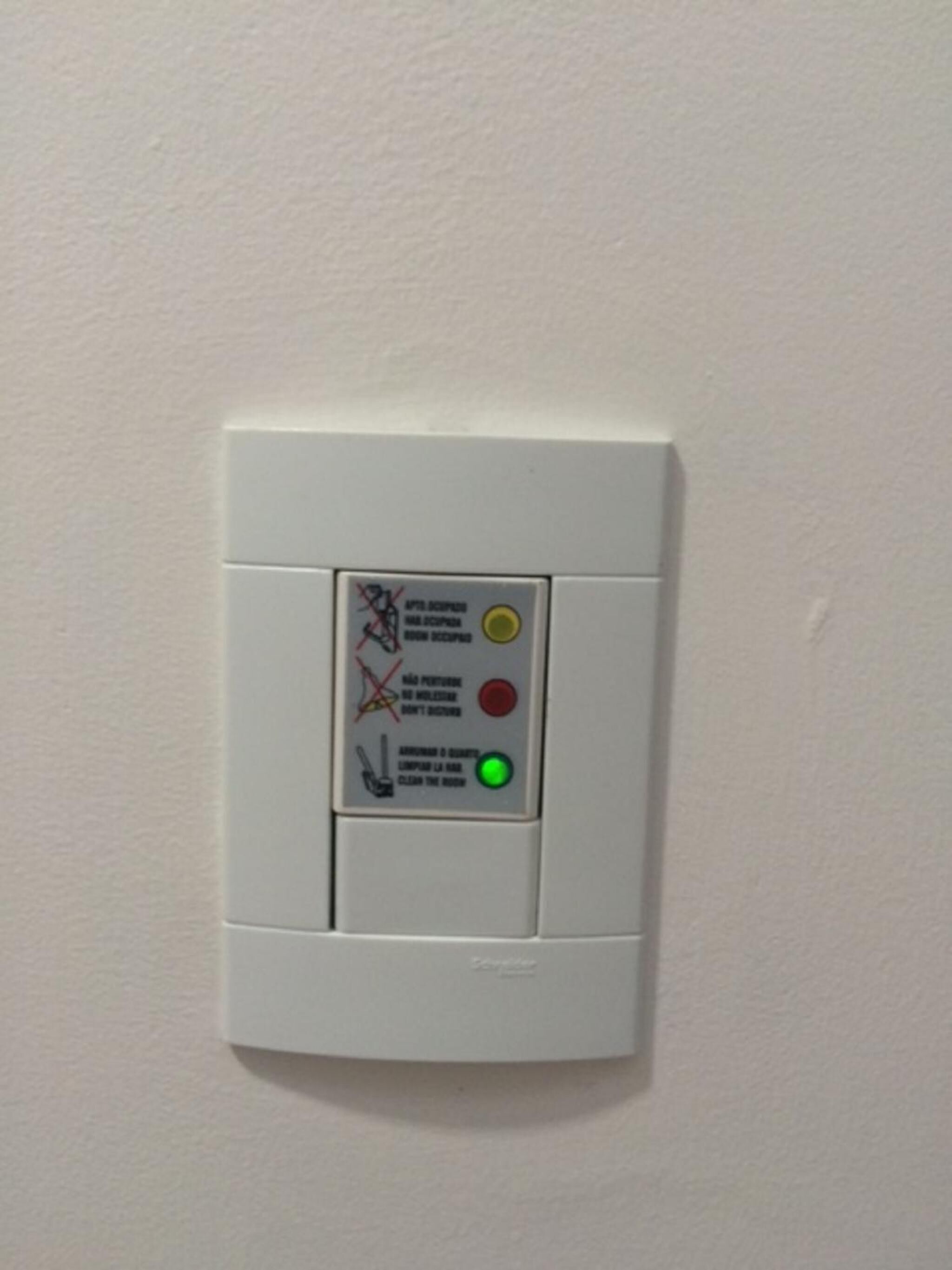 A smoke detector with a control panel on a wall.