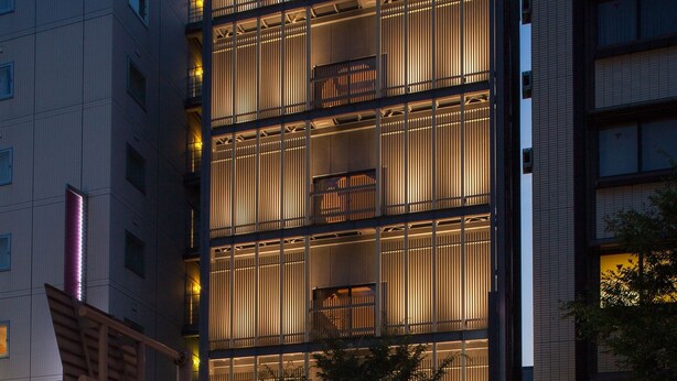 Un moderno edificio de hotel con varios pisos, ventanas amplias y una entrada destacada.
