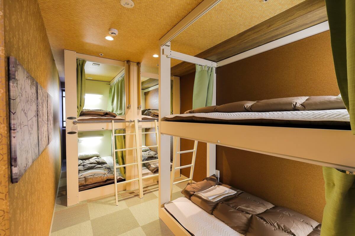 A bunk bed room with a ladder, a green curtain, and a checkered floor.