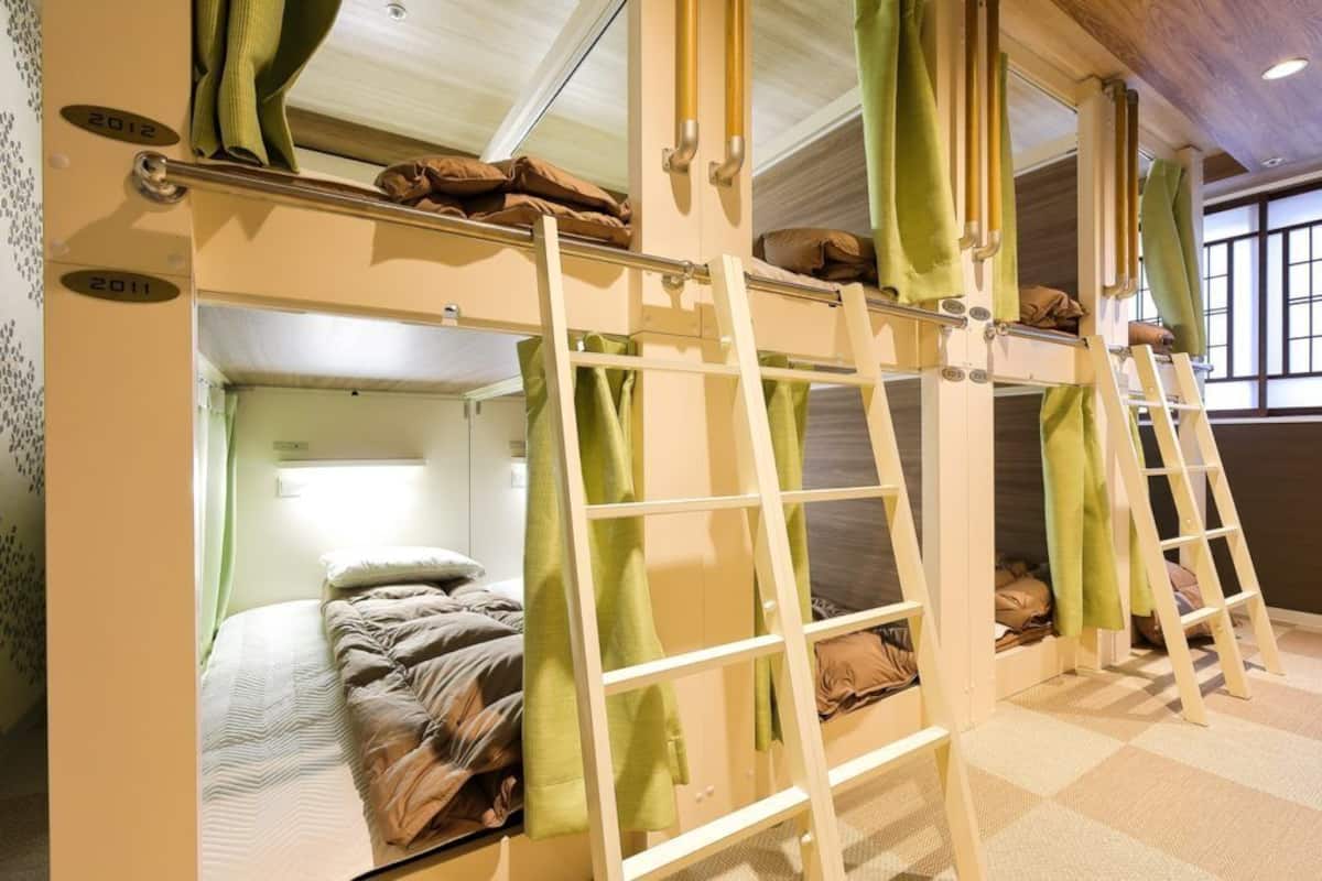 A bunk bed room with a ladder, a window, and a door.