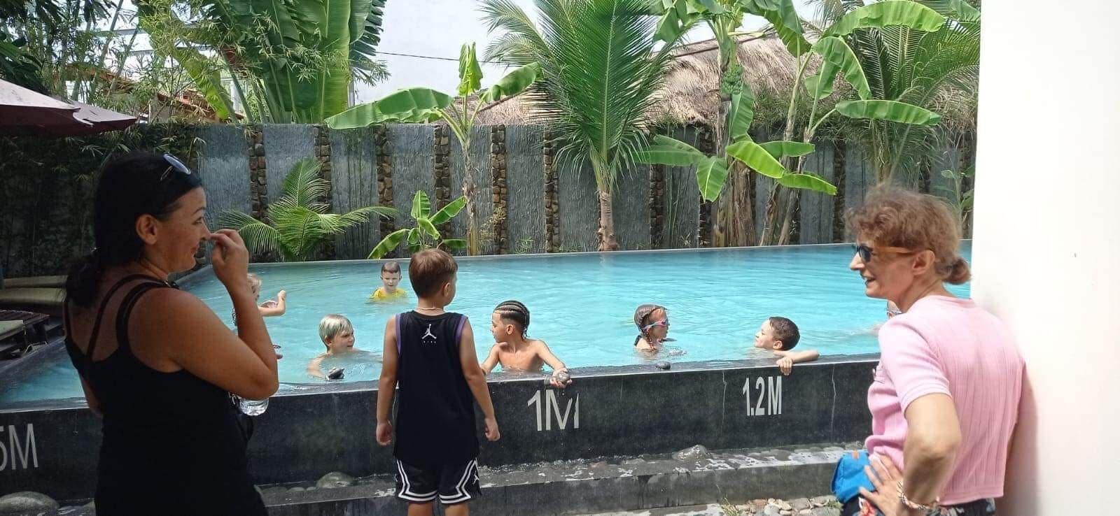 A swimming pool with children and adults.