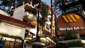Un hotel con un cartel en la entrada que dice "Mines View Park Hotel" y "MANTENTE A LA DERECHA".