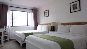 Una habitación de hotel con dos camas, un escritorio y una silla.