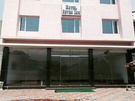 Un hotel llamado "Hotel Seven Inn" con una amplia entrada de vidrio y un suelo empedrado de ladrillo.