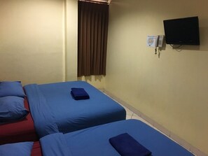 A hotel room with two beds, a TV, and a telephone. - Hotel Aceh Besar (Jakarta)
