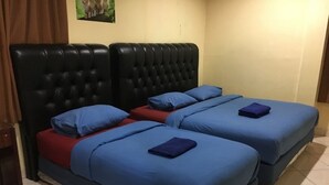 A room with two beds, each with blue bedding and a red mattress. - Hotel Aceh Besar (Jakarta)