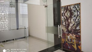 A modern interior with glass doors, a decorative wall, and a framed artwork. - Maya Heritage (Gaya)