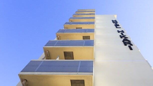 Un edificio de varios pisos, cada uno con techo plano y paneles solares.