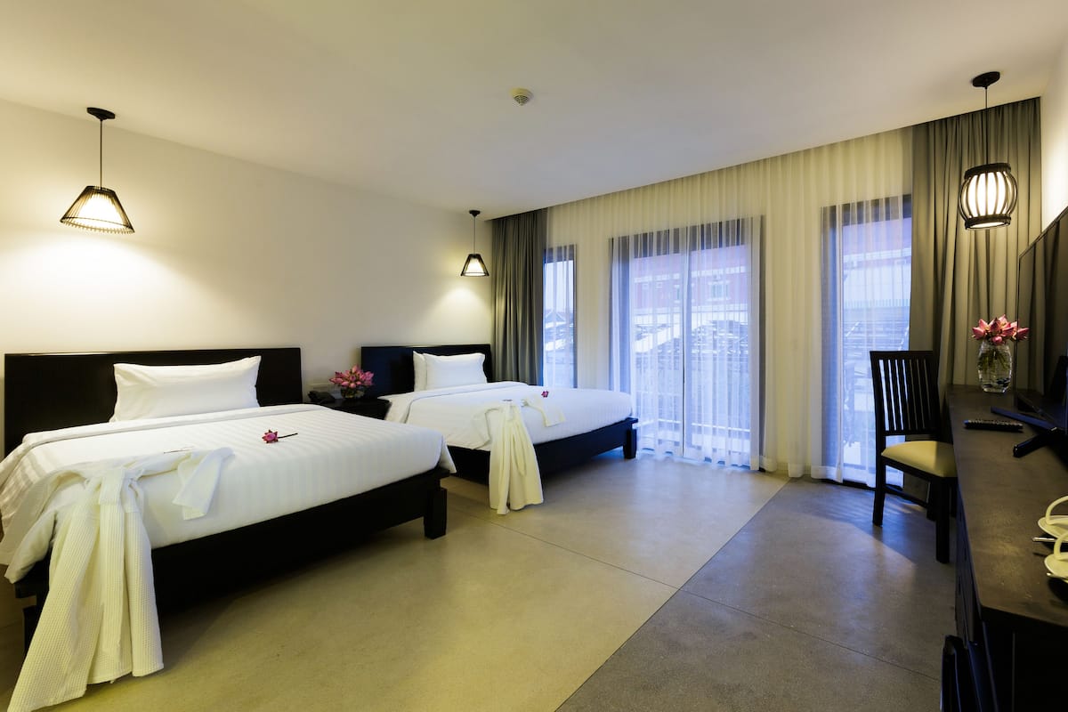 Ein Hotelzimmer mit zwei Betten, einem Schreibtisch und einem Stuhl.