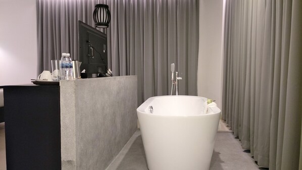 Un baño moderno con una bañera independiente, un tocador con espejo y una zona de ducha.