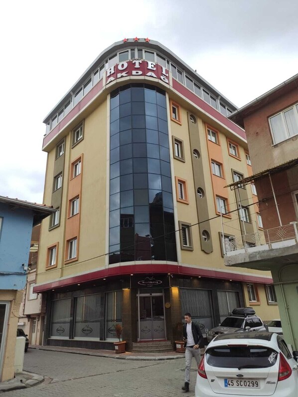 A hotel with a curved facade, multiple windows, and a prominent entrance.