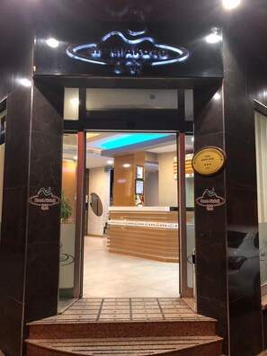 The entrance to Hotel Akdag with a reception desk, a plaque indicating a 4-star rating, and a blue-lit ceiling.