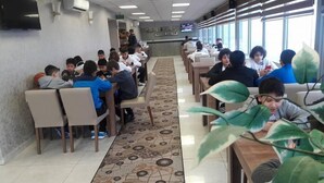 A cafeteria with long tables and chairs, a patterned floor, and large windows. - Hotel Akdag (Usak)