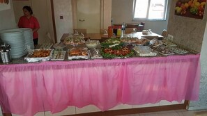 A buffet table with various food items and condiments.