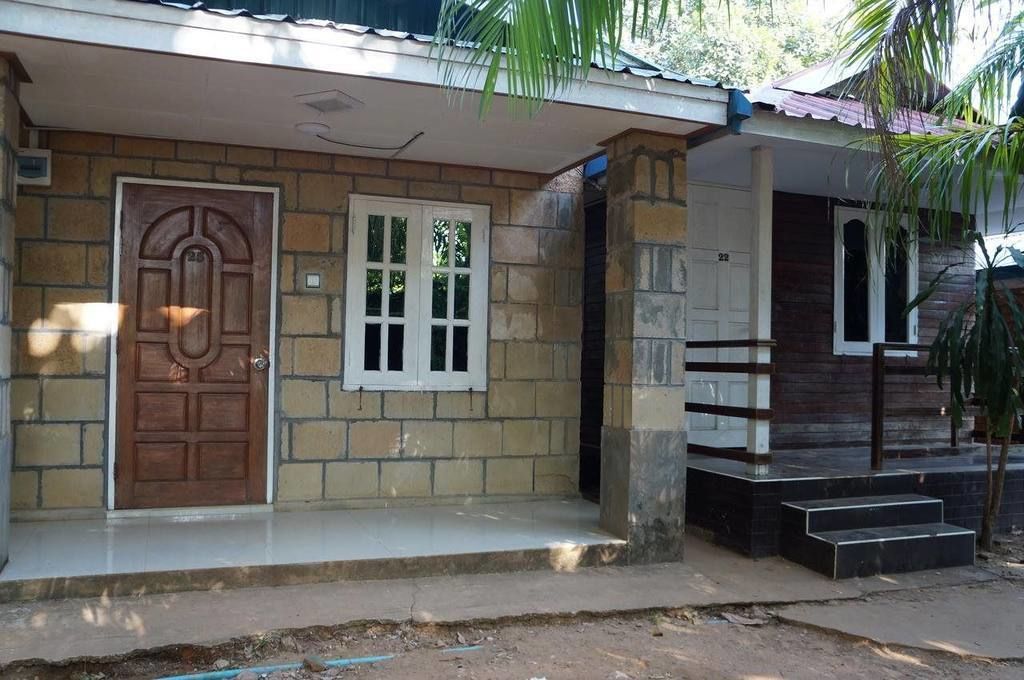 A house with a stone facade, a wooden door, and a small porch with steps.