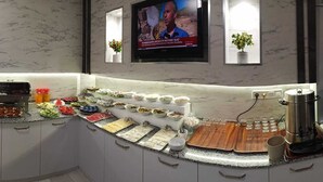 A kitchen with a marble countertop, a coffee machine, and a TV mounted on the wall. - Akdag Konaklama (Usak)