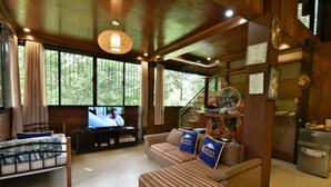 Ein gemütliches Wohnzimmer mit Sofa, Fernseher und Essbereich mit Tisch und Stühlen.