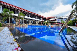 Una piscina con techo rojo, paredes de piedra y cielo azul despejado.