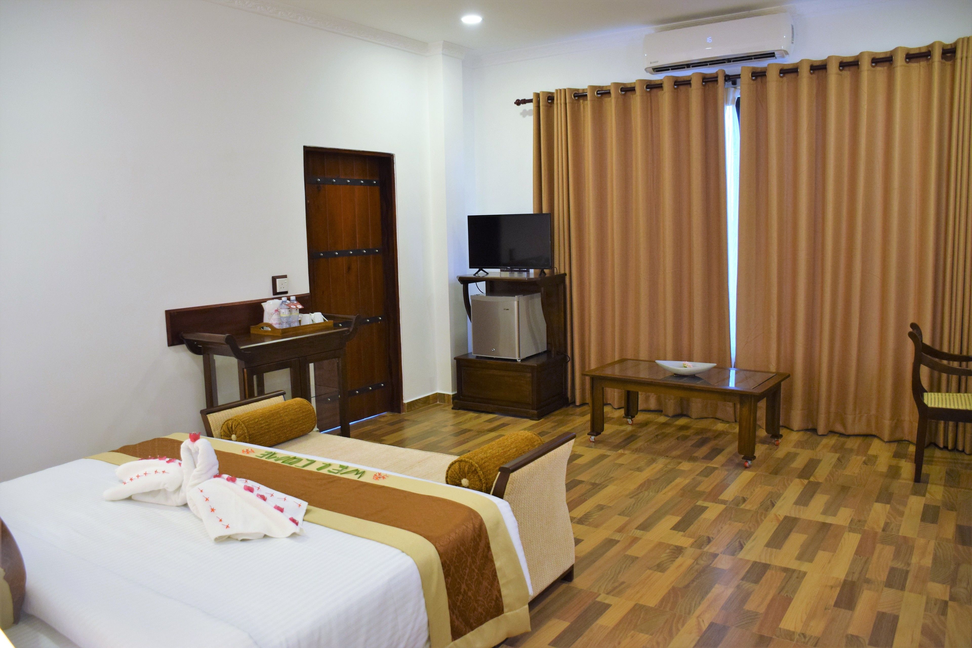 Una habitación de hotel con una cama, un escritorio con televisor, una silla y una mesa.
