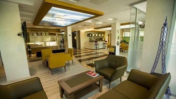 A hotel lobby with a reception desk, seating area, and a bar. - Altinpark Hotel (Kayseri)