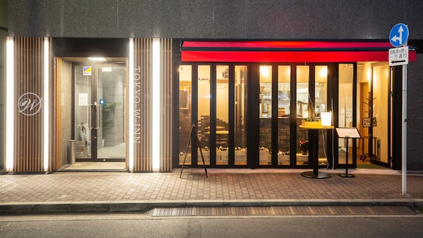 Een hotelingang met een rode luifel en een bordje dat een rokersruimte aangeeft.
