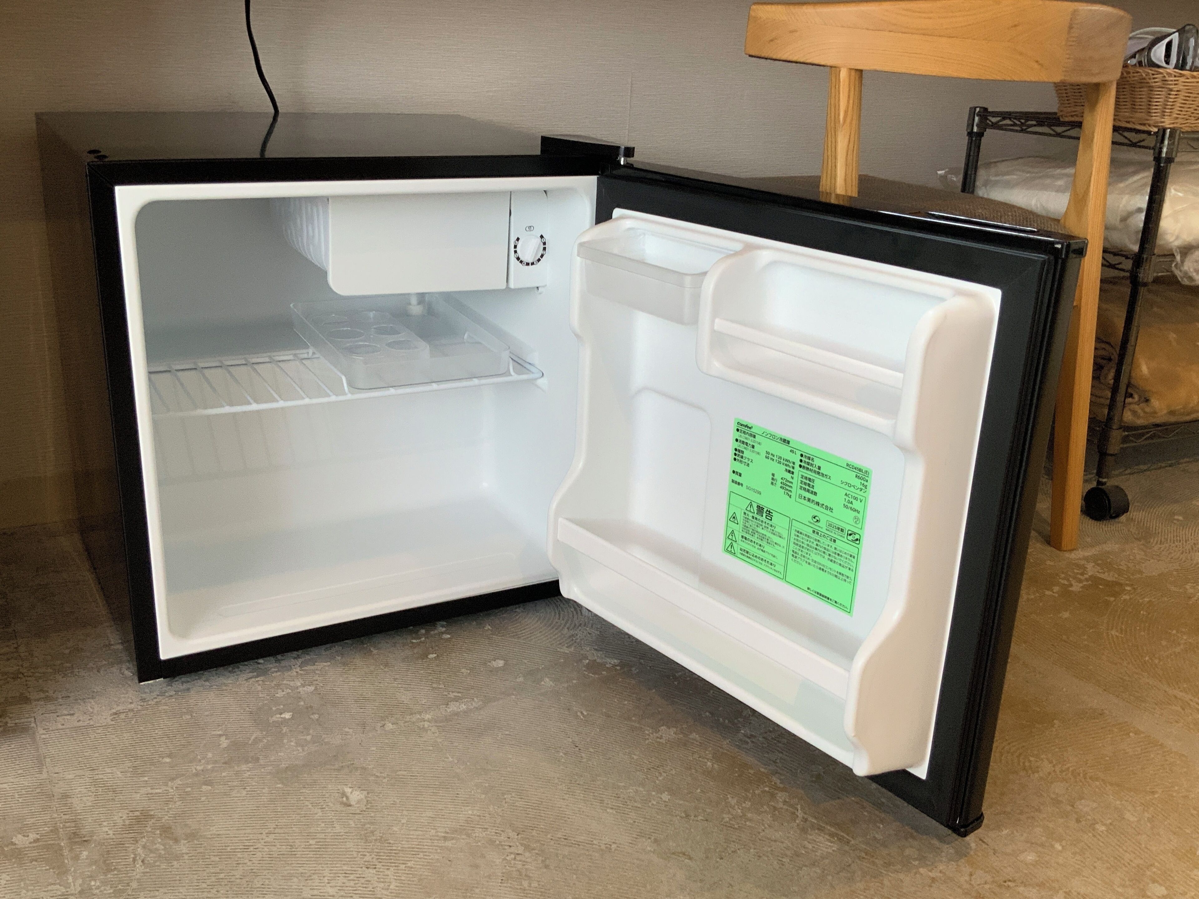 An open refrigerator with a control panel and a label inside.