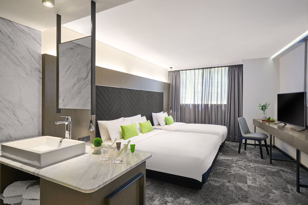 Une chambre d’hôtel moderne dotée d’un grand lit, d’un bureau, d’une télévision et d’une salle de bain avec un lavabo en marbre.