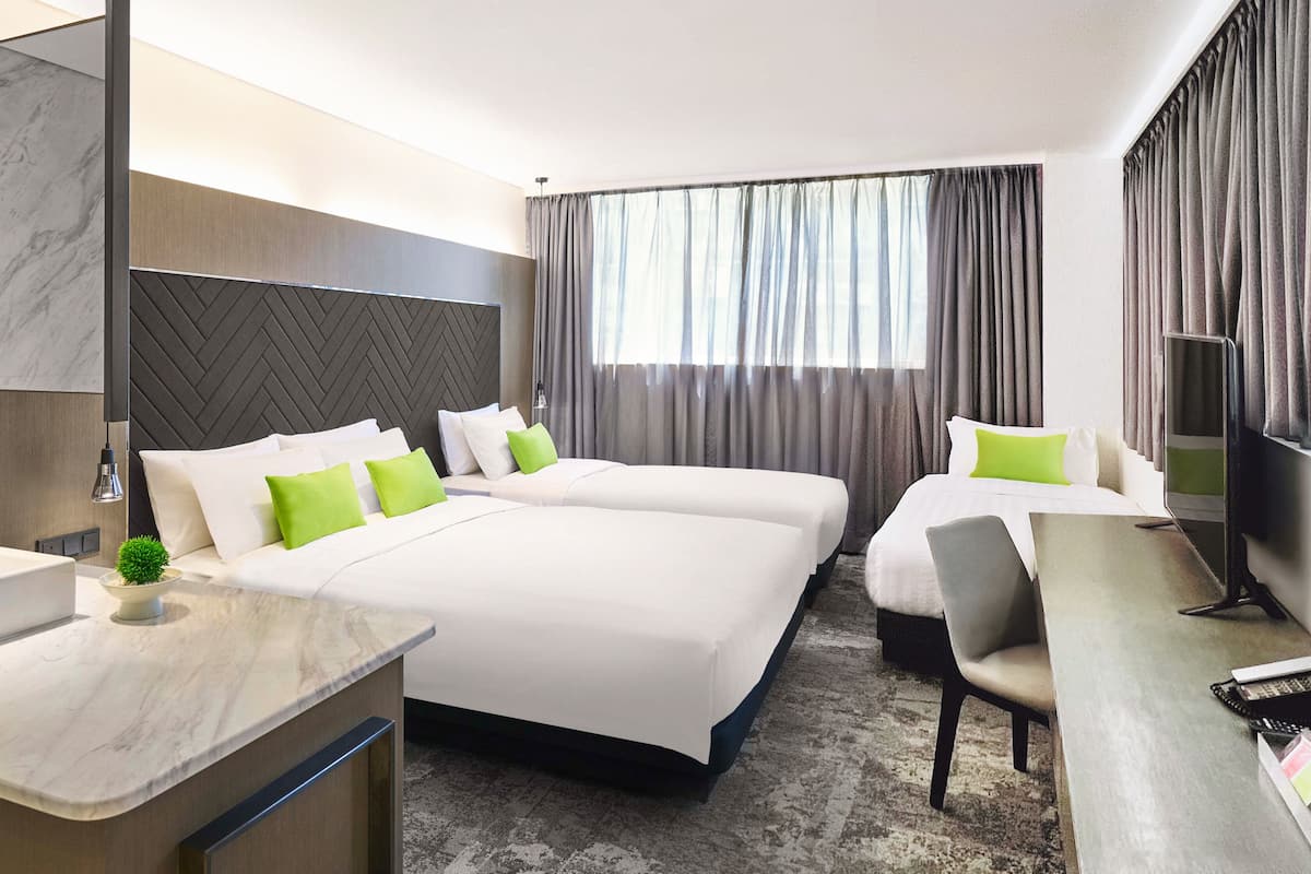 Une chambre d’hôtel avec deux lits, un bureau, une télévision et un comptoir en marbre.