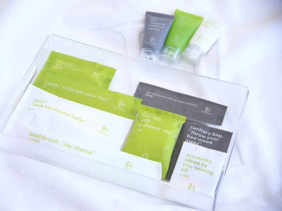 A tray with various toiletries including a toothbrush, comb, razor, and sanitary bag.