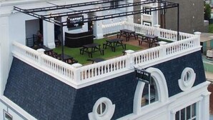 A rooftop terrace with outdoor seating and a bar area. - The Homee Cozy Modern Studio Apartment (Ho Chi Minh City)