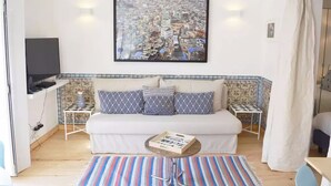 A cozy living room with a sofa, a coffee table, and a television. - Chiado Blue by Homing (Lisbon)