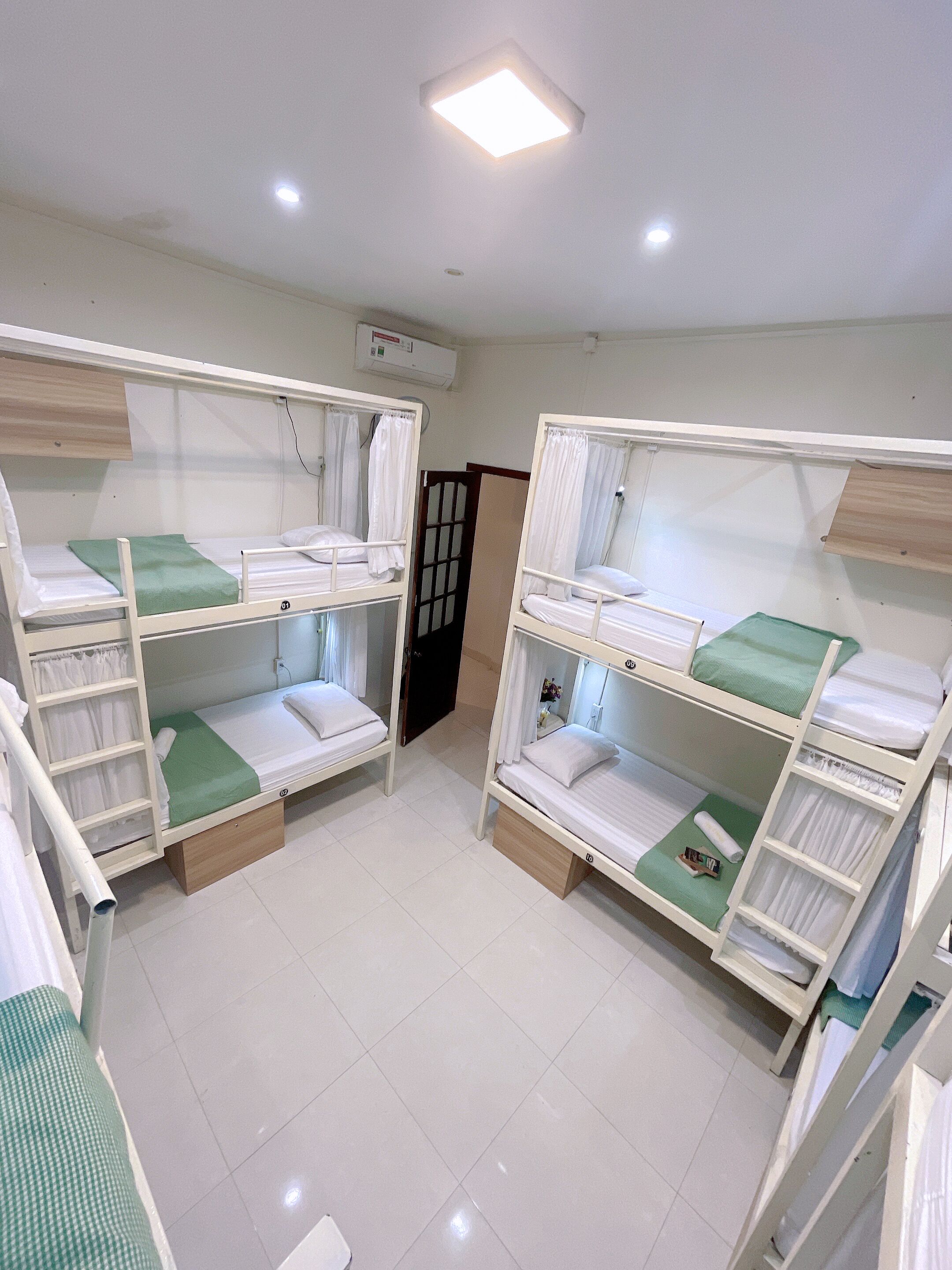 A room with bunk beds, a door, and a ceiling light.