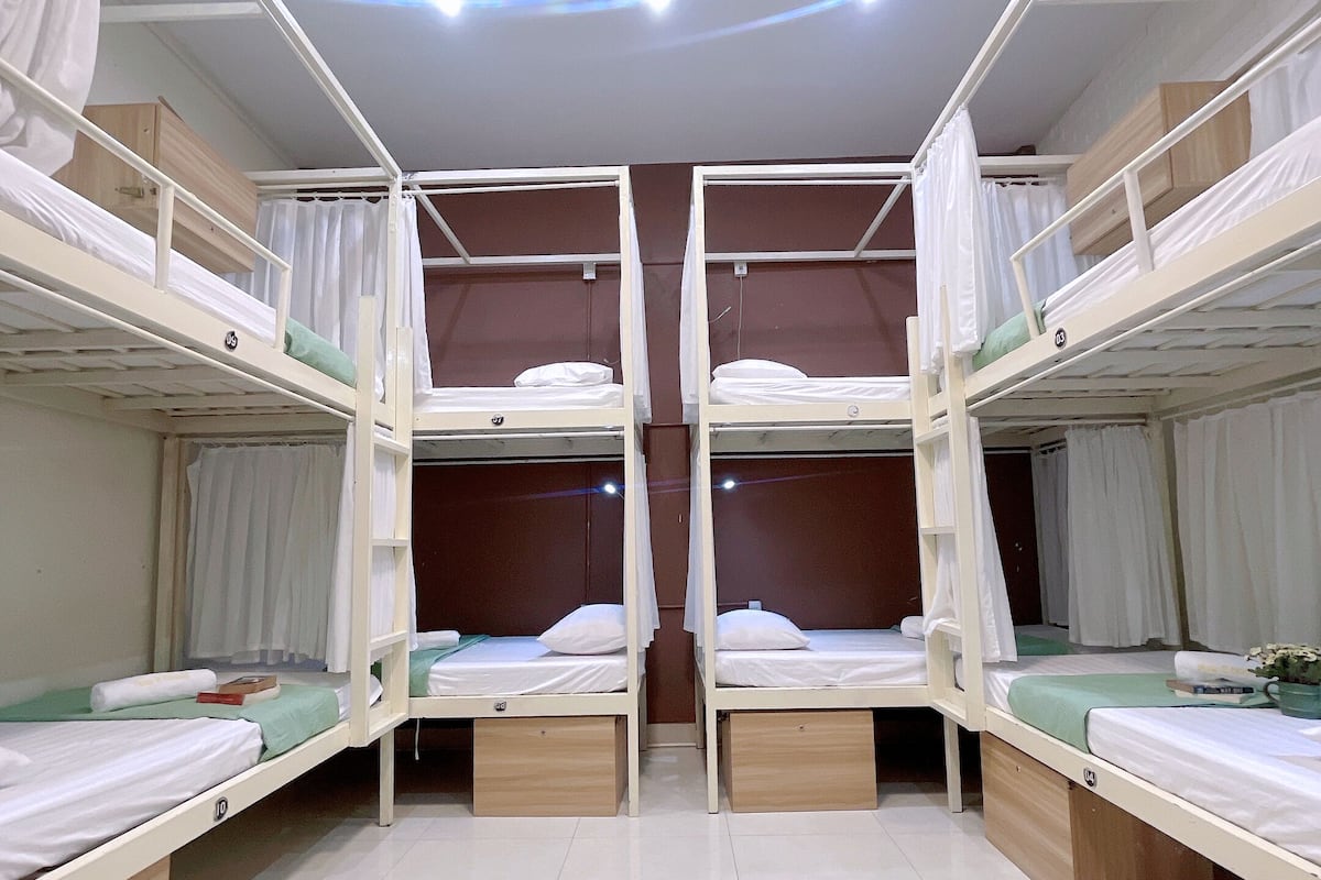 A room with four bunk beds arranged in a symmetrical layout.