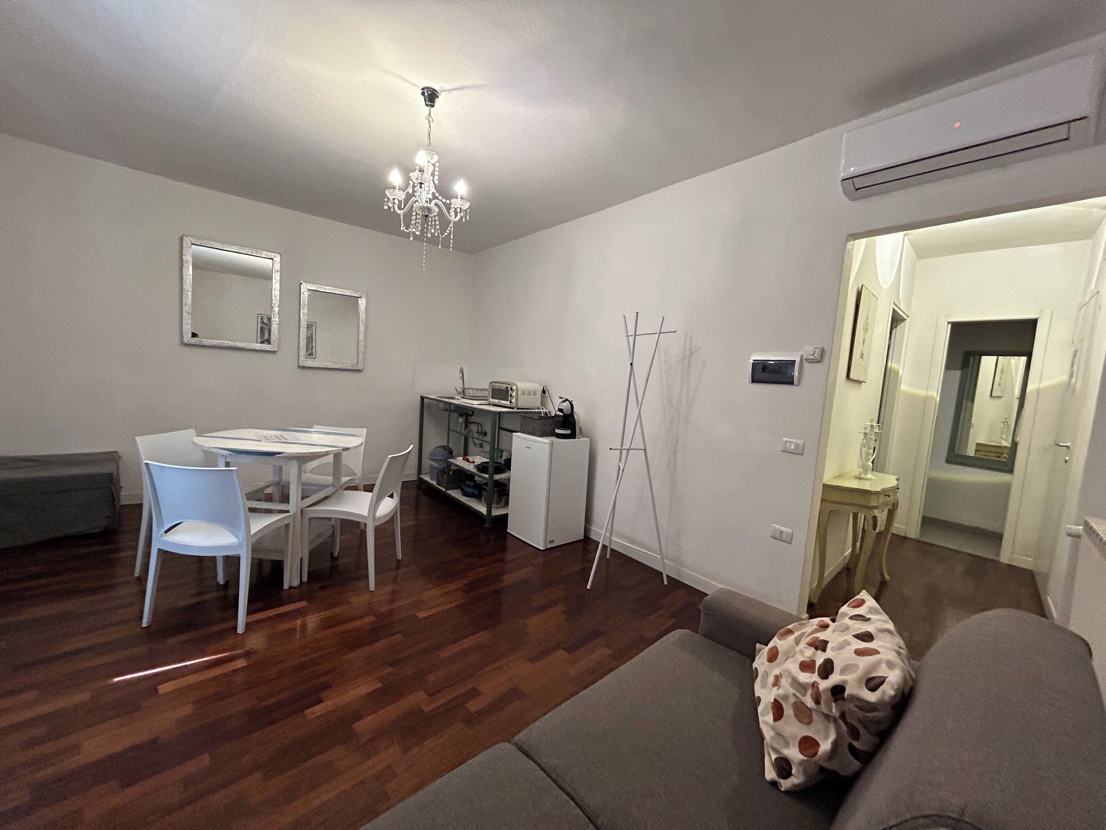 A compact living space with a dining area, kitchenette, and a sofa.