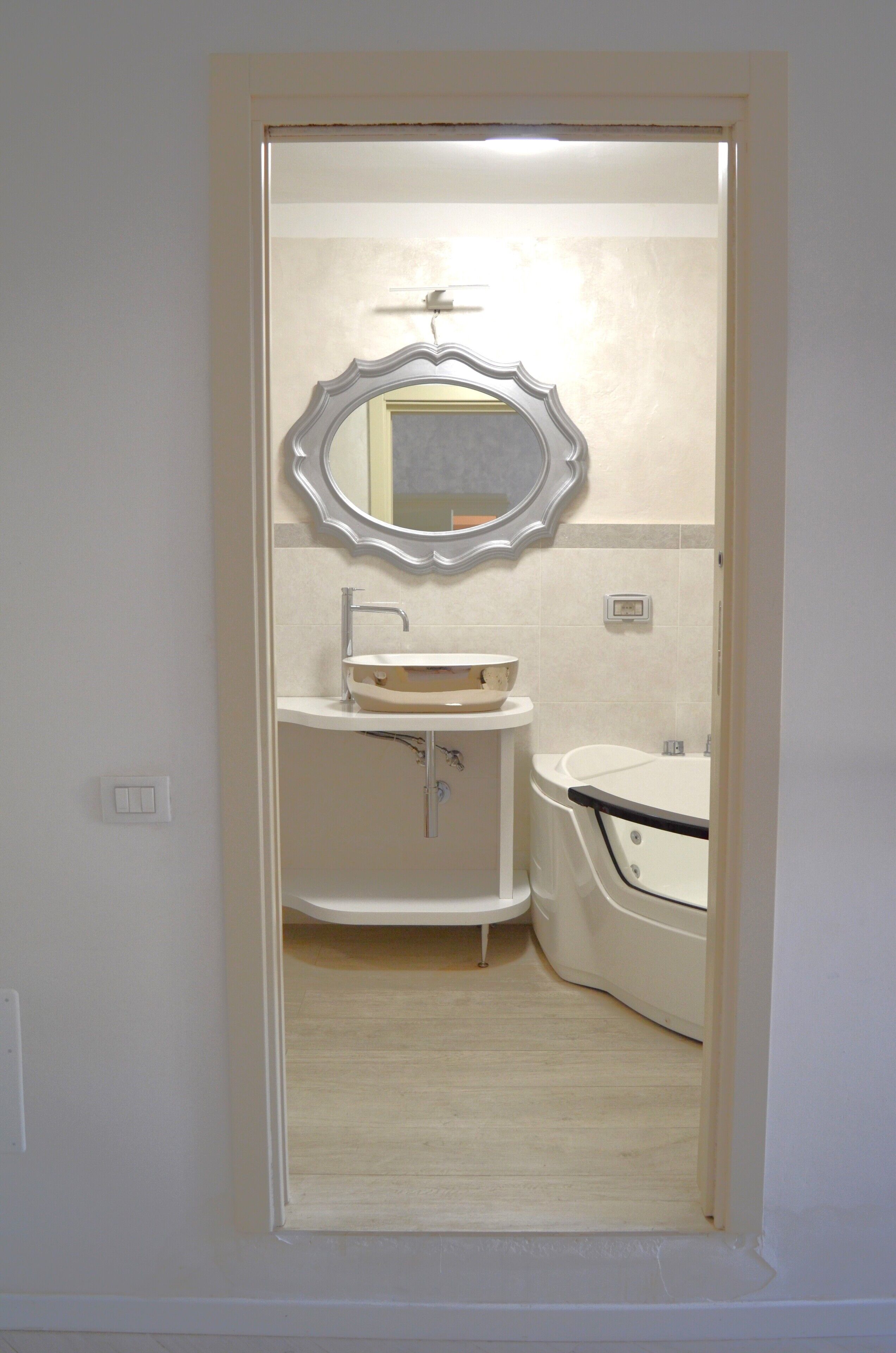 Un baño con un tocador blanco, un lavabo y una bañera.