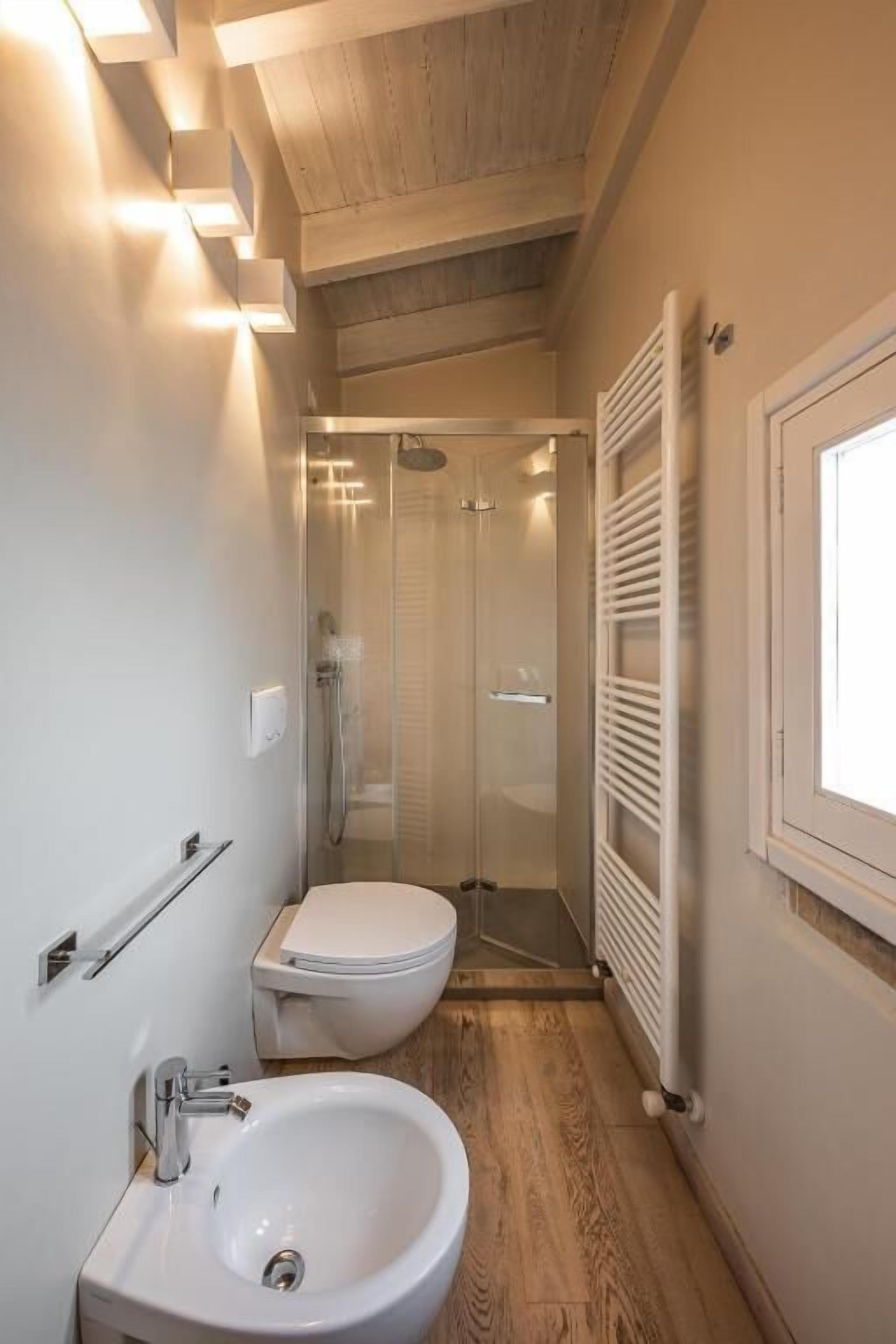 Une petite salle de bain comprenant une douche, des toilettes et un lavabo.