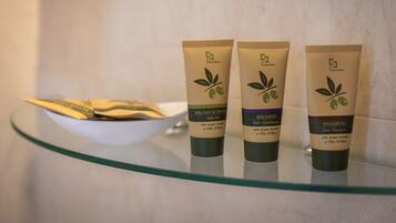 Three tubes of bath and hair care products on a glass shelf.