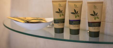 Three tubes of bath and hair care products on a glass shelf.