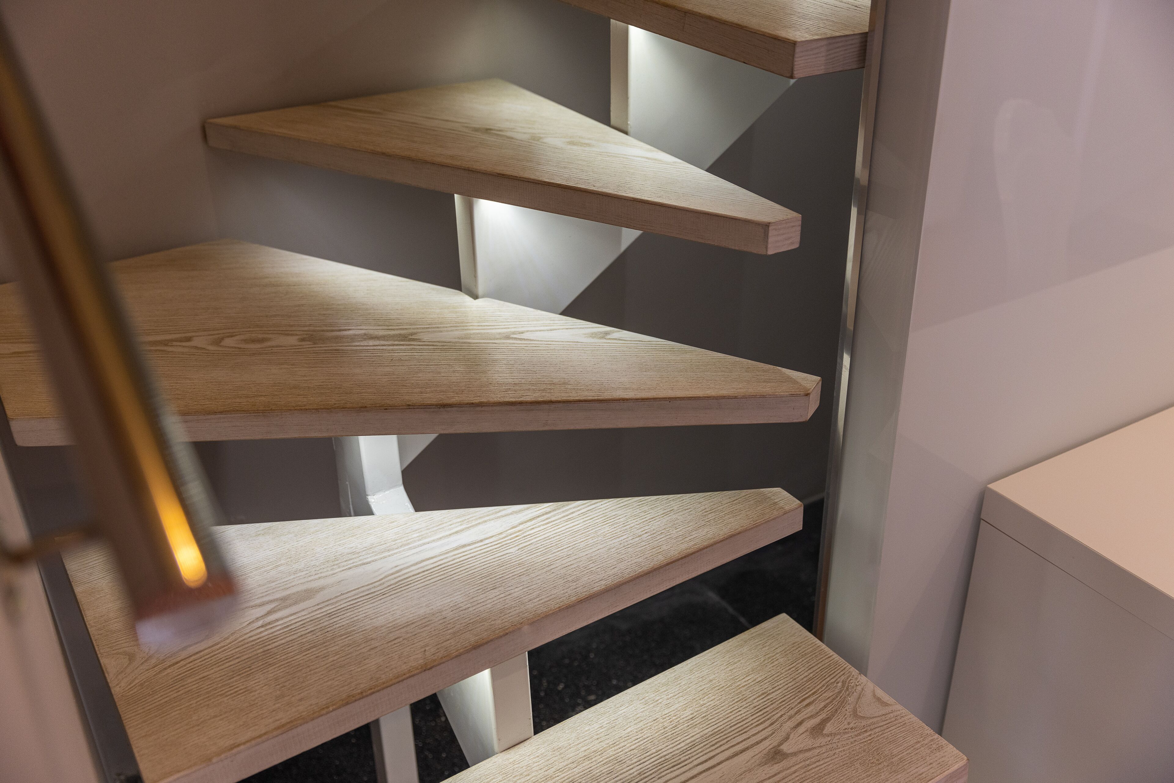 Una escala moderna amb graons de fusta i barana metàl·lica.